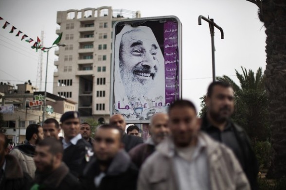 Palestinians gather near a poster of late Hamas spiritual leader Sheikh Ahmed Yassin during celebrations for the 24th anniversary of the foundation of the Islamist movement in Gaza City on December 14, 2011. AFP PHOTO/MARCO LONGARI