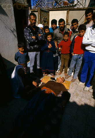 10 Feb 1988, Gaza, Gaza Strip --- A civilian woman lies wounded on the ground, surrounded by relatives. She was one of the victims of violence after rebel Israeli and Palestinian fighters protested in the occupied territory of Gaza during the first Intifada. --- Image by Patrick Robert/Sygma/CORBIS