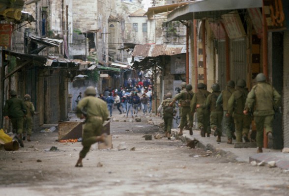 19 Feb 1988, Nablus, West Bank --- Soldiers face off against Palestinian demonstrators during a protest in the streets of Nablus after the Friday Prayer. Violence broke out after rebel Israeli and Palestinian fighters protested in the disputed territory of West Bank during the first Intifada. --- Image by Patrick Robert/Sygma/CORBIS