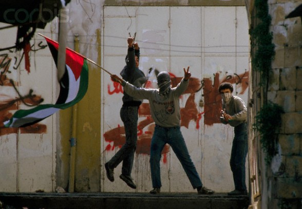 19 Feb 1988, Nablus, West Bank --- Demonstrators waving Palestinian Liberation Organization flags protest in the streets of Nablus after the Friday Prayer. Violence broke out after rebel Israeli and Palestinian fighters protested in the disputed territory of West Bank during the first Intifada. --- Image by Patrick Robert/Sygma/Corbis