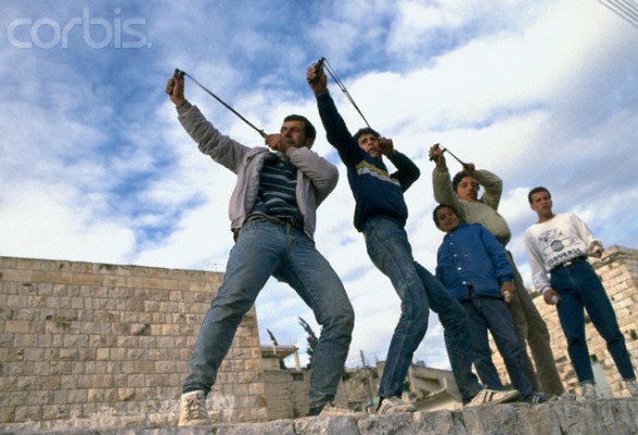 24 Feb 1988, Beit Ummar, West Bank --- Palestinian demonstrators throw stones at Israeli soldiers during a protest in the streets of Beit Omar. Violence broke out after rebel Israeli and Palestinian fighters protested in the disputed territory of West Bank during the first Intifada. | Location: Beit Omar, West Bank.  --- Image by Patrick Robert/Sygma/CORBIS