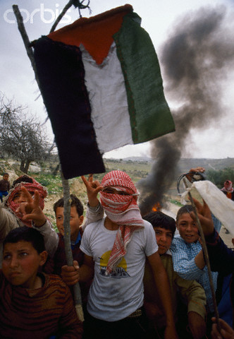 February 1988, West Bank --- Young Palestinian demonstrators wave Palestinian Liberation Organization flags, outlawed by Israel, during an uprising. Violence broke out after rebel Israeli and Palestinian fighters protested in the disputed territory of West Bank during the first Intifada. --- Image by  Patrick Robert/Sygma/CORBIS