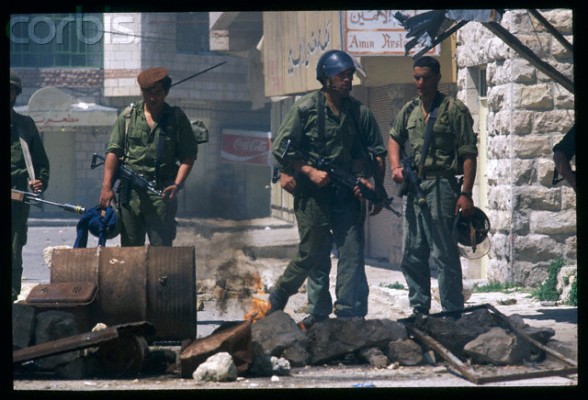 03 Apr 1988, Al-Bireh, West Bank --- Israeli soldiers confront a smoldering barricade while on patrol in the town of Al Birah during the Intifada. | Location: Al Birah, West Bank.  --- Image by  Bernard Bisson/Sygma/Corbis
