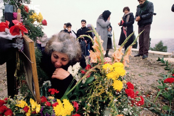 25 Dec 1988, Jerusalem, Israel --- A Palestinian family visits the grave of 15-year-old Nidel, who was killed in the Intifada, a violent uprising by Palestinians against the Israeli occupation. --- Image by Ricki Rosen/CORBIS SABA