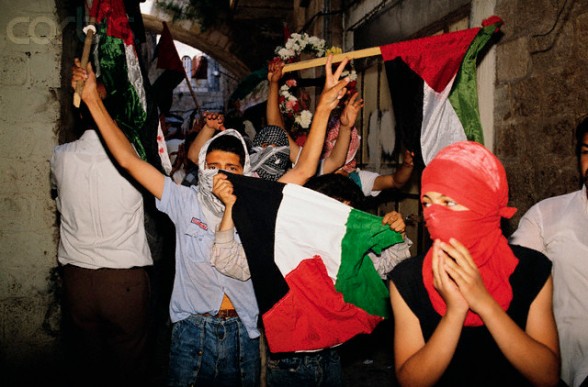 11 Apr 1989, Jerusalem, Israel --- Masked Palestinians wave flags at a funeral for a slain Palestinian who was killed during the unrest. --- Image by Ricki Rosen/CORBIS SABA