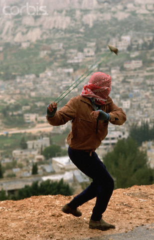 ca. 1988, Nablus, West Bank --- Palestinian Slinging a Rock --- Image by Peter Turnley/CORBIS