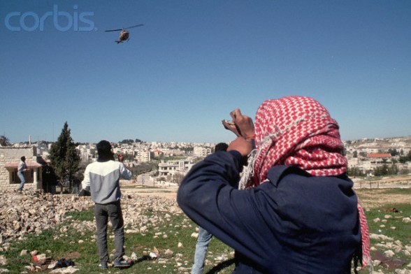 16 Mar 1988, West Bank --- Palestinians throw rocks at a helicopter of the occupying Israeli military forces. --- Image by  Peter Turnley/CORBIS