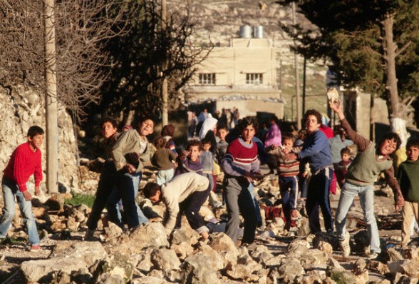 1988, West Bank --- Palestinian boys throw rocks at Israeli soldiers in the West Bank. --- Image by Peter Turnley/CORBIS