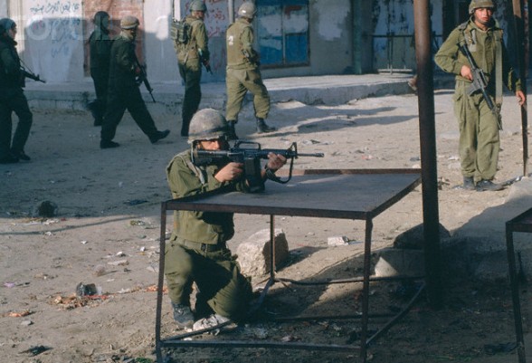 1993, Gaza, Gaza Strip --- An Israeli soldier aims his assault rifle during a 1993 Palestinian uprising in Gaza. --- Image by Peter Turnley/CORBIS