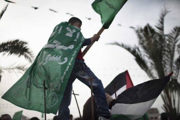 A Palestinian boy waves Hamas party flag