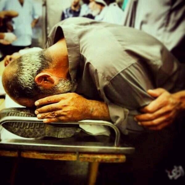 Martyr journalist Khaled Hamad's father kisses his foot & say the last goodbye. via  ‏@HindSaeed1 